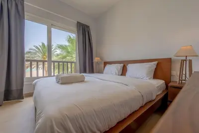 a bedroom with a large bed and a balcony at Peaceful 2-Bedroom in Waterside, El Gouna. Pool & Lagoon in Hurghada