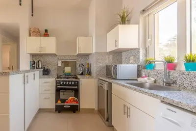 a kitchen with white cabinets and a stove top oven at Peaceful 2-Bedroom in Waterside, El Gouna. Pool & Lagoon in Hurghada