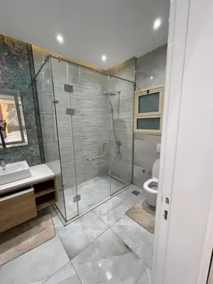a bathroom with a glass shower and a toilet at Hurghada-Magawish Villa 1 in Hurghada