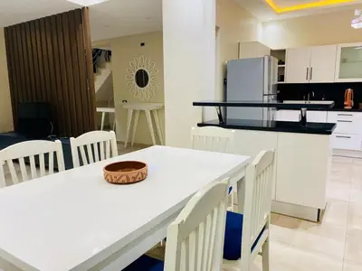 a kitchen and dining room with a table and chairs at Hurghada-Magawish Villa 1 in Hurghada