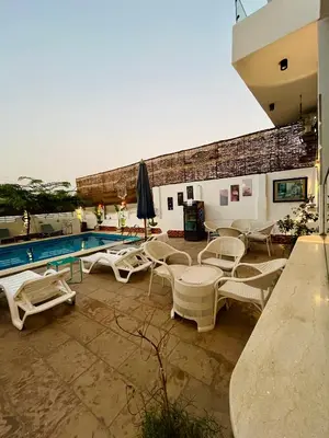 a patio with chairs and a swimming pool at Flower Of Life Hotel in Luxor