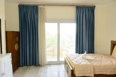 a bedroom with a bed and a sliding glass door at Flamingo Boutique hotels in Luxor