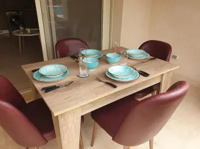 a wooden table with blue bowls and plates on it at Mangroovy - Delicate 1BR Ground floor by the Pool in Hurghada