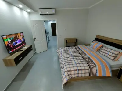 a bedroom with a bed and a flat screen tv at Scandic Cinde in Hurghada