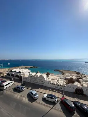 a parking lot with cars parked next to the ocean at BLUE ViEW SUiTES in Hurghada