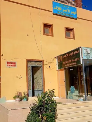 a yellow building with a sign in front of it at Azazi house in Quseir