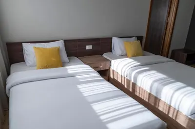 two beds with yellow pillows in a room at Al Dora Residence Suites Hurghada in Hurghada