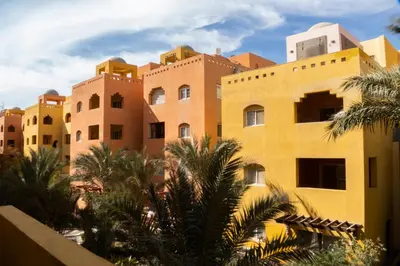 a group of buildings with palm trees in front at Al Dora Residence Suites Hurghada in Hurghada