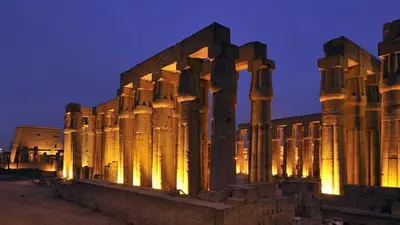an ancient building with columns at night at Royal Home Luxor Nile View in Luxor