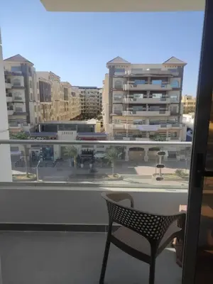 a chair on a balcony with a view of a city at Scandic Resort - Mido Chalet in Hurghada