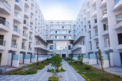 an apartment building with a garden in front of it at Scandic Resort - Mido Chalet in Hurghada