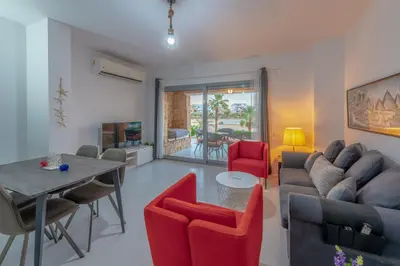 a living room with a couch and a table and chairs at New! Lovely 1BR in Swan Lake, Gouna. Azure Lagoon in Hurghada