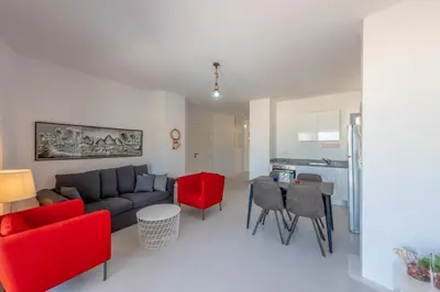 a living room with a couch and red chairs at New! Lovely 1BR in Swan Lake, Gouna. Azure Lagoon in Hurghada