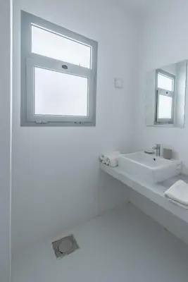a white bathroom with a sink and a window at New! Lovely 1BR in Swan Lake, Gouna. Azure Lagoon in Hurghada