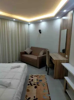 a room with a bed and a couch and a table at شاليه السعادة in Hurghada