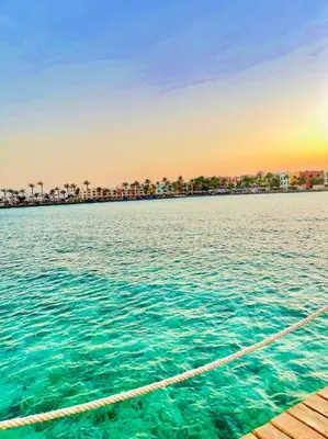 a boat on the water with a city in the background at شاليه السعادة in Hurghada