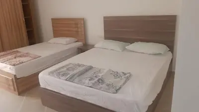 two beds in a small room with white sheets at casa di nonna in Hurghada