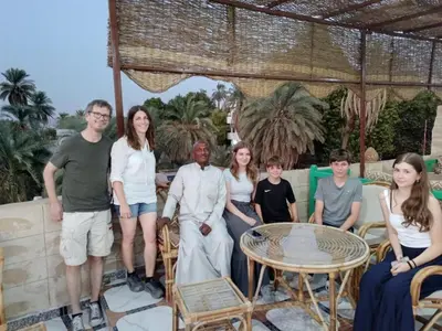 a group of people posing for a picture on a patio at ABU Nubian Guest House in Aswan