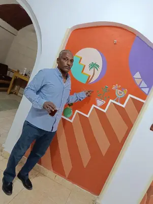 a man standing in front of a surfboard at ABU Nubian Guest House in Aswan