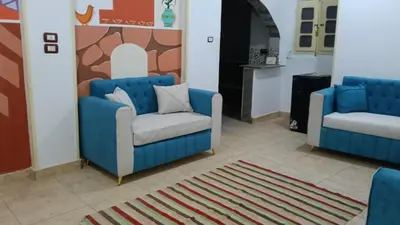 two blue chairs in a room with a rug at ABU Nubian Guest House in Aswan