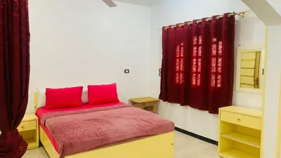 a bedroom with a bed with red pillows on it at ABU Nubian Guest House in Aswan
