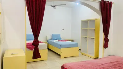 a bedroom with two beds and a mirror at ABU Nubian Guest House in Aswan