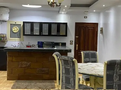 a kitchen with a bar with a table and chairs at Amwaj Compound in Hurghada