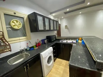 a kitchen with a sink and a washing machine at Amwaj Compound in Hurghada