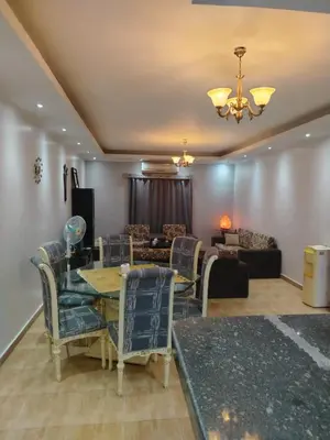 a living room with a table and chairs and a couch at Amwaj Compound in Hurghada