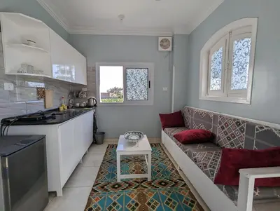 a living room with a couch and a kitchen at Villa Rebecca in Luxor