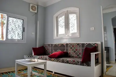 a living room with a couch and two windows at Villa Rebecca in Luxor