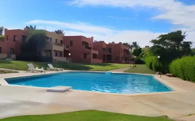 a swimming pool in front of a villa at Chalet Stella Makadi Beach 5* in Hurghada