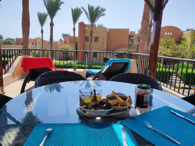 a table with a bowl of food on top of it at Chalet Stella Makadi Beach 5* in Hurghada