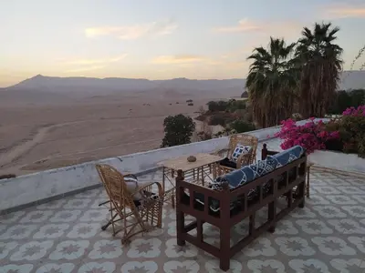 a patio with a table and chairs and a view of the desert at Gabawy Garden Ferienwohnung in Luxor