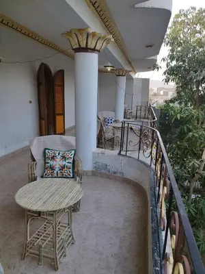 a balcony with a table and a chair on a house at Gabawy Garden Ferienwohnung in Luxor