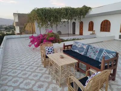 a patio with a couch and tables and chairs at Gabawy Garden Ferienwohnung in Luxor