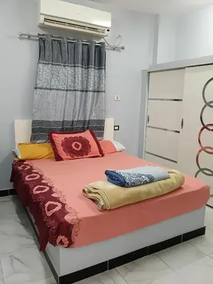 a bed with colorful pillows on it in a room at Hamo Fathy Nubian House in Aswan