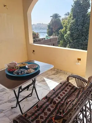a table with a plate of food on a balcony at Hamo Fathy Nubian House in Aswan