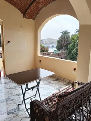 a table and chairs in a room with a window at Hamo Fathy Nubian House in Aswan