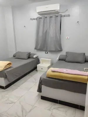 two beds sitting in a room with a window at Hamo Fathy Nubian House in Aswan