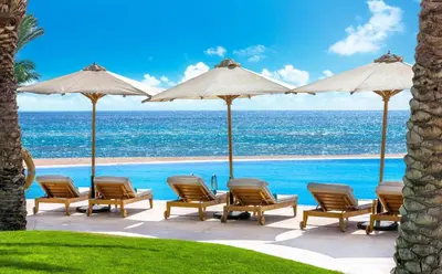 a group of chairs and umbrellas next to a pool at Baron Palace Sahl Hasheesh in Hurghada