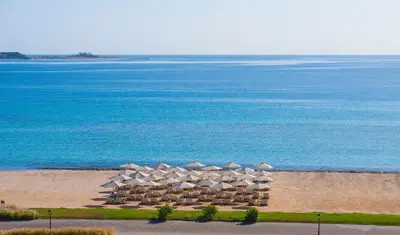 an aerial view of a beach with umbrellas and the ocean at Baron Palace Sahl Hasheesh in Hurghada