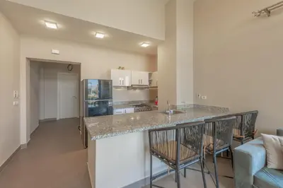 a kitchen with a counter top in a living room at NEW! 2BR Duplex in Tawila, Gouna Private Jacuzzi, Garden, Lagoon & Pool in Hurghada