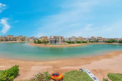 a view of a beach with buildings in the background at NEW! 2BR Duplex in Tawila, Gouna Private Jacuzzi, Garden, Lagoon & Pool in Hurghada