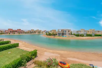 an orange car parked on the shore of a beach at NEW! 2BR Duplex in Tawila, Gouna Private Jacuzzi, Garden, Lagoon & Pool in Hurghada