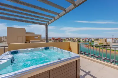 a hot tub on the balcony of a apartment at NEW! 2BR Duplex in Tawila, Gouna Private Jacuzzi, Garden, Lagoon & Pool in Hurghada