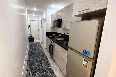 a small kitchen with a refrigerator and a sink at 2 Bed Flat - Sleeps 6 - Pool - Parking - Wifi in Hurghada