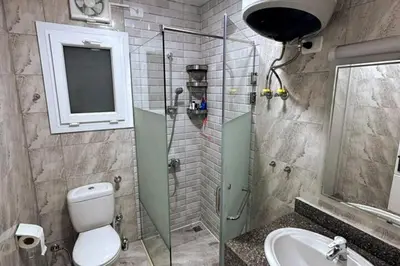 a bathroom with a toilet and a sink and a shower at 2 Bed Flat - Sleeps 6 - Pool - Parking - Wifi in Hurghada