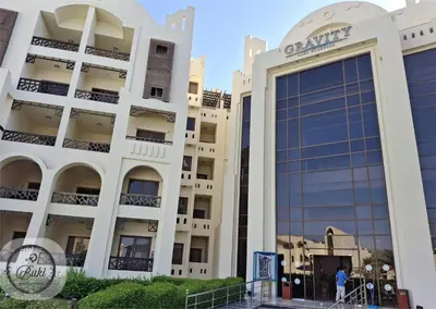 a man walks in front of a building at Sea View at Gravity Sahl Hasheesh 7 Pools & Beach-FOR GUESTS WITH NONEGYPTIAN PASSPORTS in Hurghada