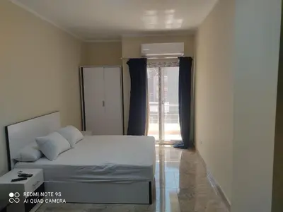 a bedroom with a bed and a large window at Magawish District in Hurghada